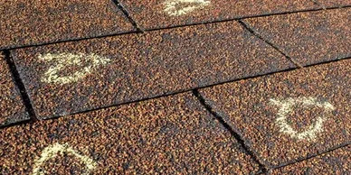 Insurance Adjuster marked hail damage on a insureds roof.